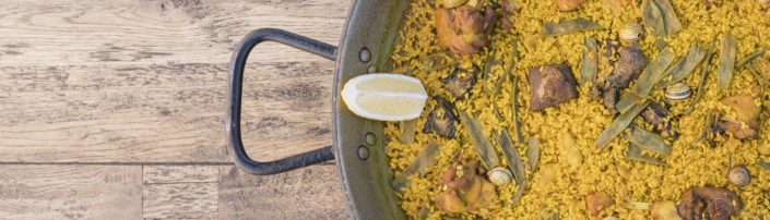Detalle de paella sobre mesa de madera Detalle de paella sobre mesa de madera