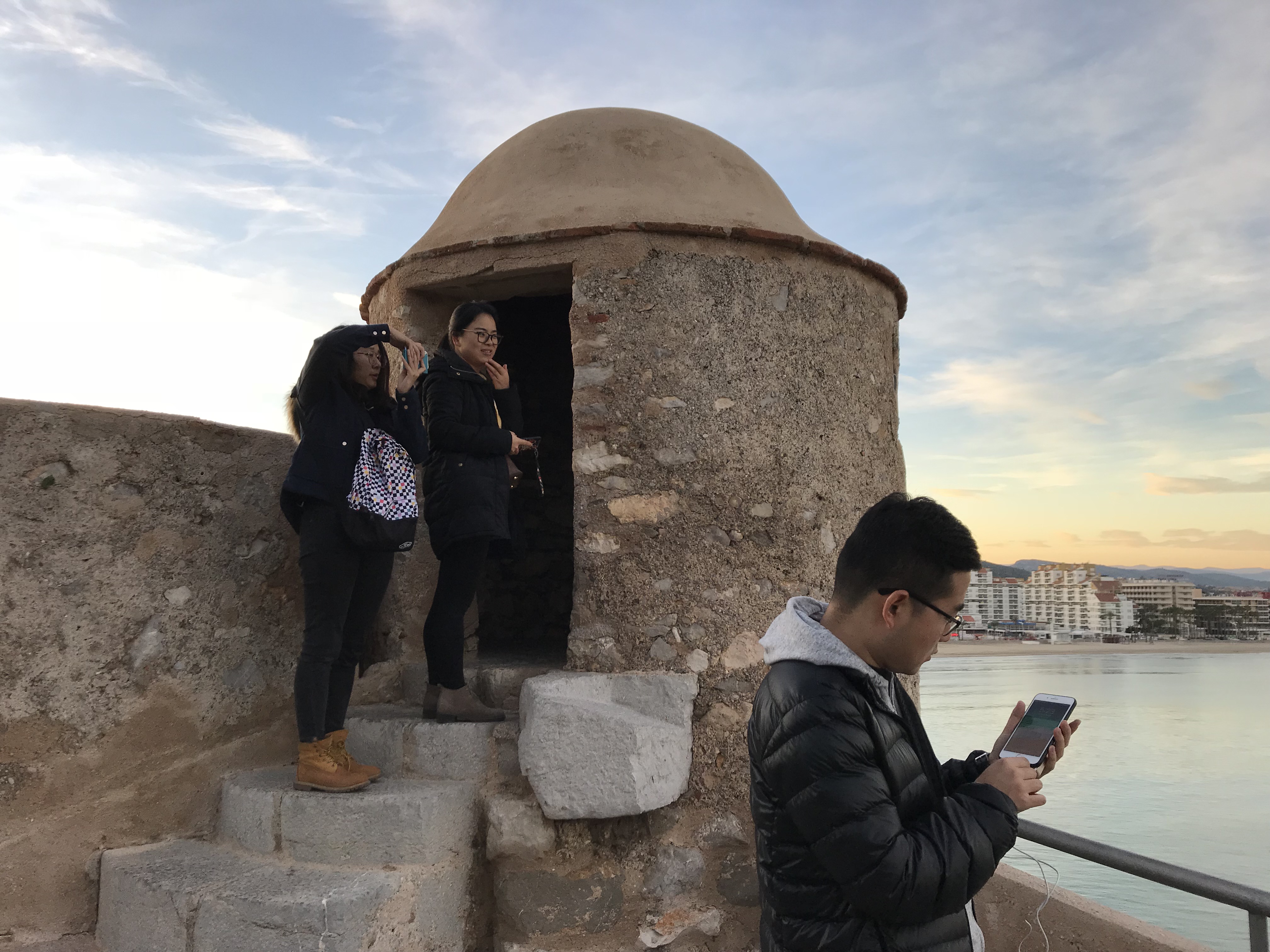 Turistas chinos en Peñíscola usando sus móviles